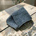 Folded grey bamboo cloth on a wooden surface with 'Fire Horse Botanicals' branding.