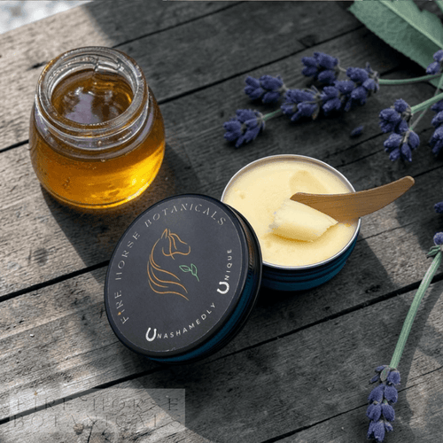 Tub of 'Fire Horse Botanicals' product  with a jar of honey on a wooden surface with lavender flowers.
