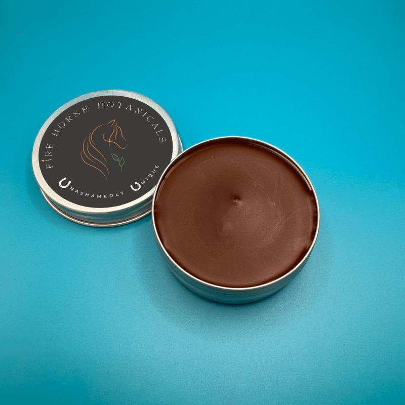 Open tin of Fire Horse Botanicals balm on a blue background