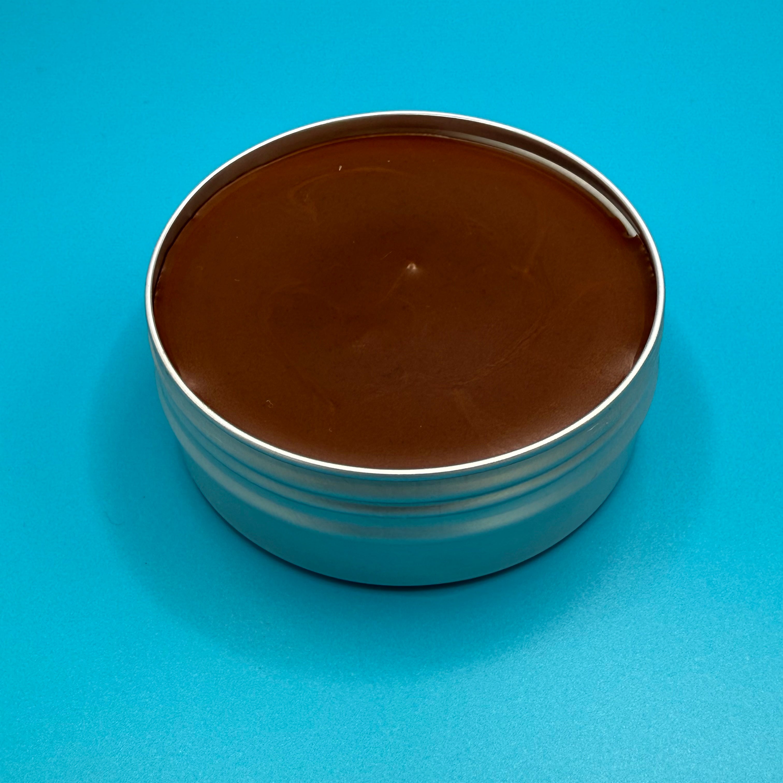 Tin of 'Fire Horse Botanicals' balm on a blue background