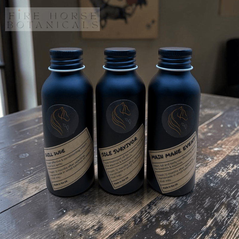 Three bottles with labels on a wooden surface, featuring 'Fire Horse Botanicals' branding.