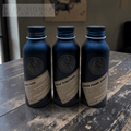 Three bottles with labels on a wooden surface, featuring 'Fire Horse Botanicals' branding.