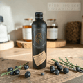 Bottle of Fire Horse Botanicals on a wooden surface with berries and herbs.