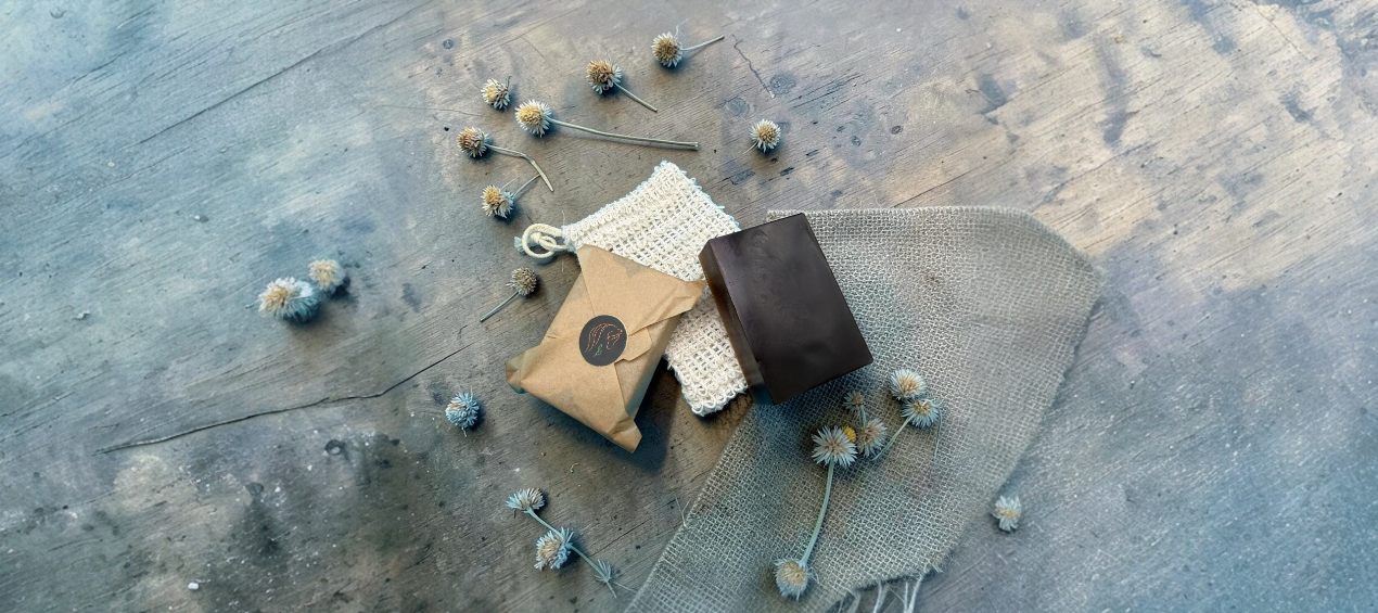 Fire Horse Botanicals soaps and sisal bag on a textured surface with dried flowers