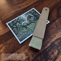 Wooden brush with a 'Fire Horse Botanicals' postcard on a wooden surface